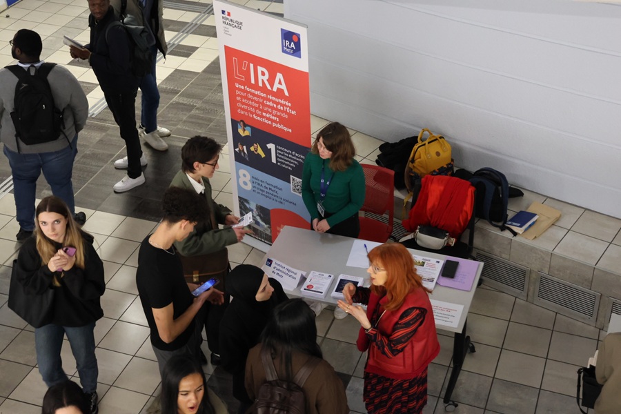 Des étudiants se renseignant sur le stand de l'IRA disposé dans l'atrium