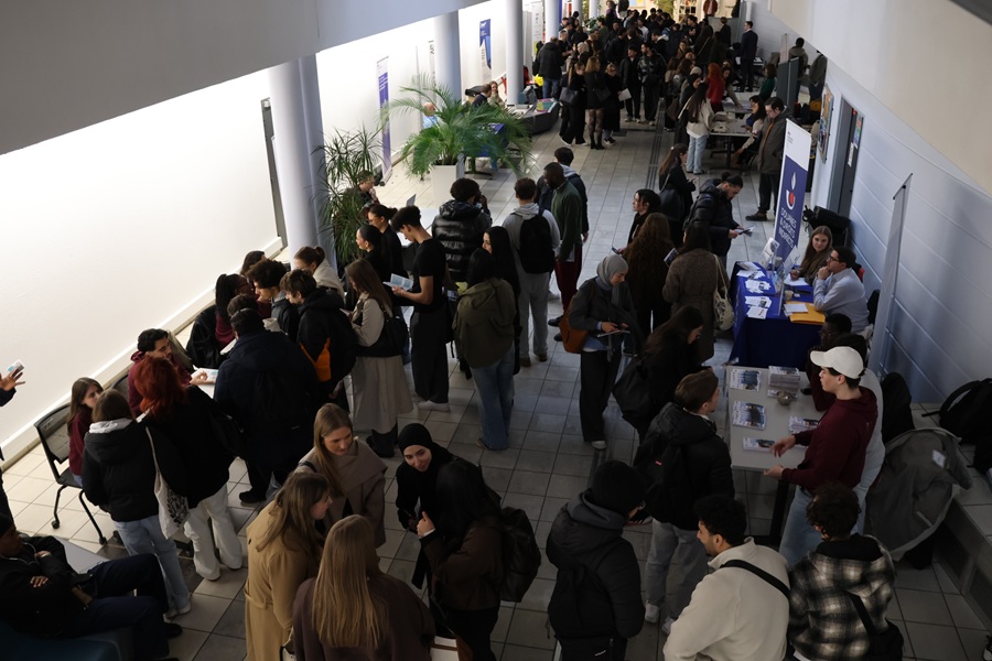 Des étudiants se renseignant sur le stand de l'IRA disposé dans l'atrium